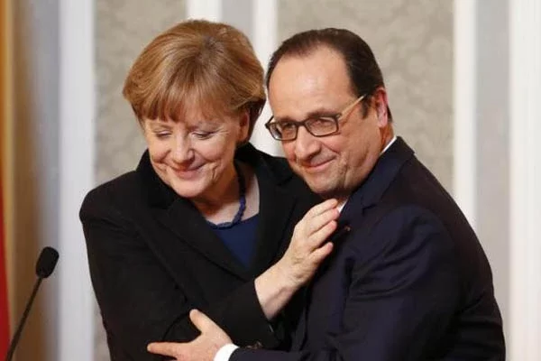 Ангела Меркель і Франсуа Алянд пазуюць для фотографаў пасля 16-гадзінных начных перамоваў. Фота Ройтэрз.