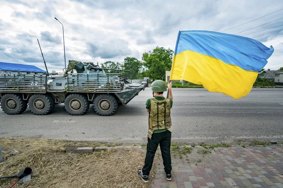 Хлопчык размахвае ўкраінскім сцягам, калі бронетранспарцёр украінскай арміі накіроўваецца да Бахмуцкай лініі фронту ў Славянску, 27 чэрвеня 2023 г. Фота: Celestino Arce / NurPhoto via Getty Images